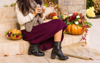 A girl sits on the stoop, perhaps Inn on Barons Creek, surrounded by fall decor and pumpkins.