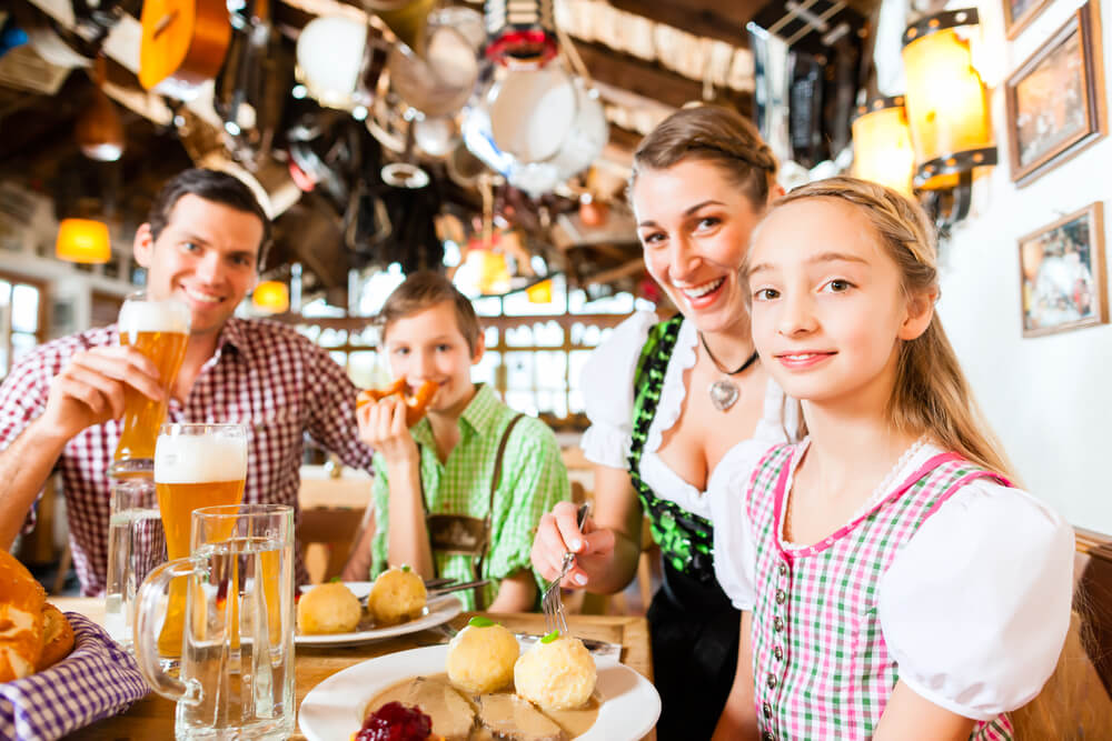Family of four enjoys a Bavarian-themed dinner at a German restaurant in historic Fredericksburg, TX.