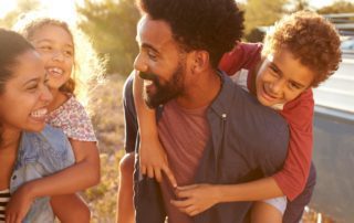 A family smiles at each other during their kid-friendly vacation in Fredericksburg, TX.